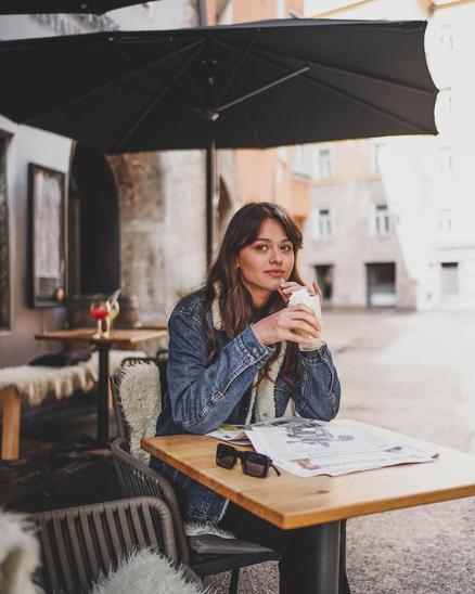 A man and a woman laughing while sitting under a black parasol