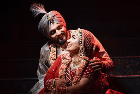 Groom and bride holding hands during royal wedding procession