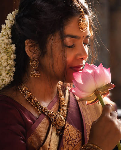 Smiling bride under red veil and rose petals