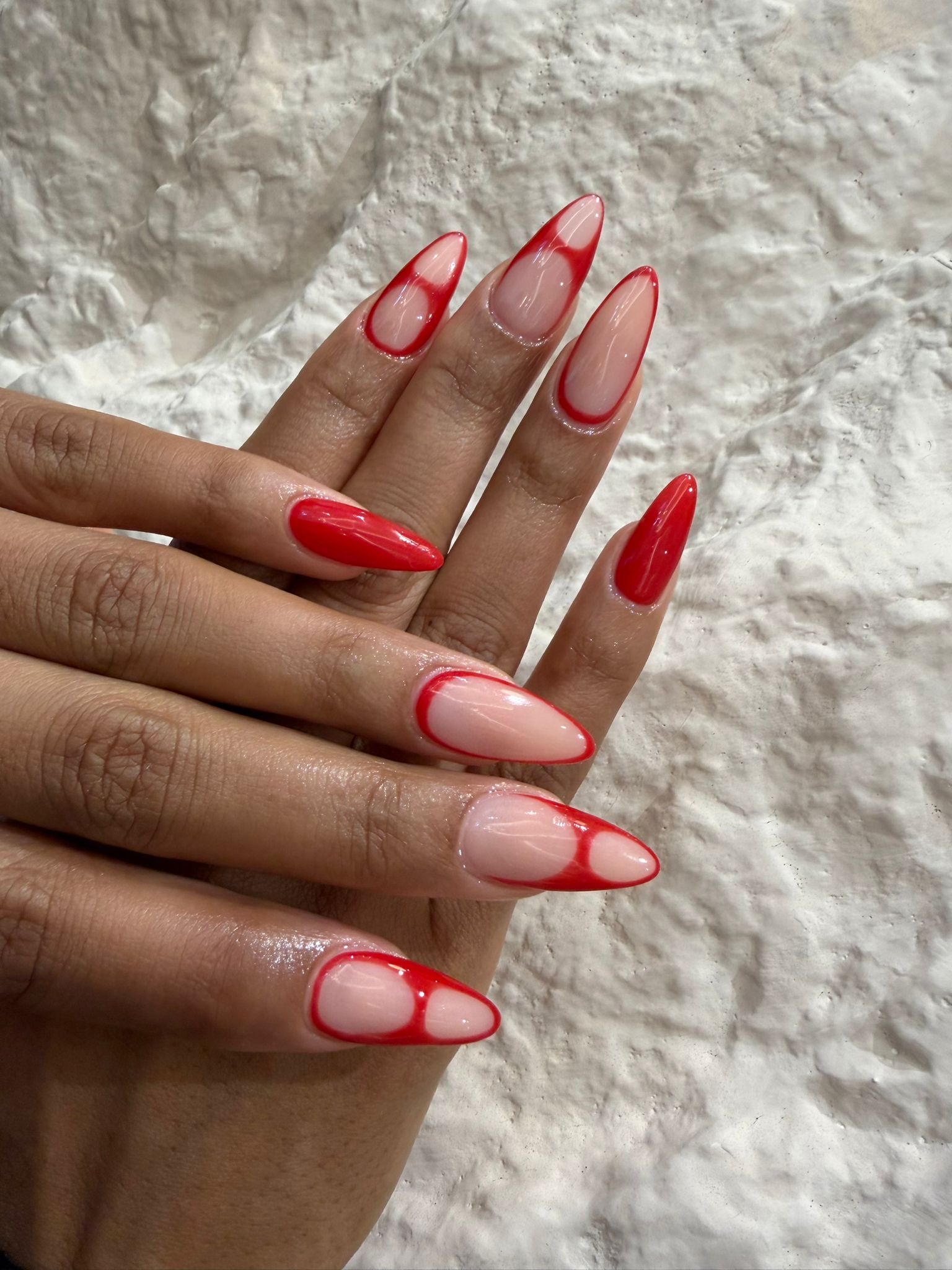 Almond nails with vivid red negative-space line art
