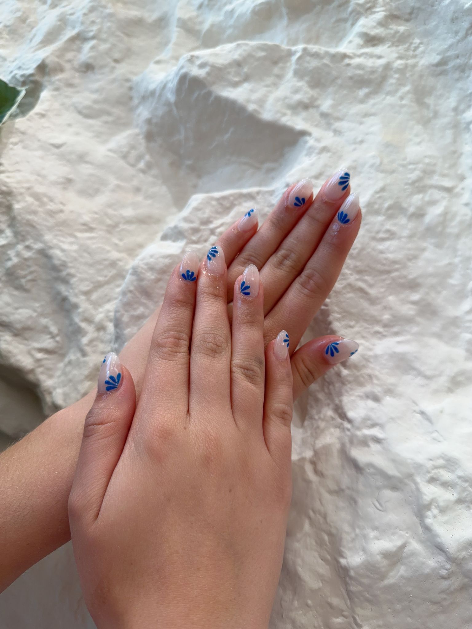 Sheer almond nails with hand-painted cobalt blue petal details