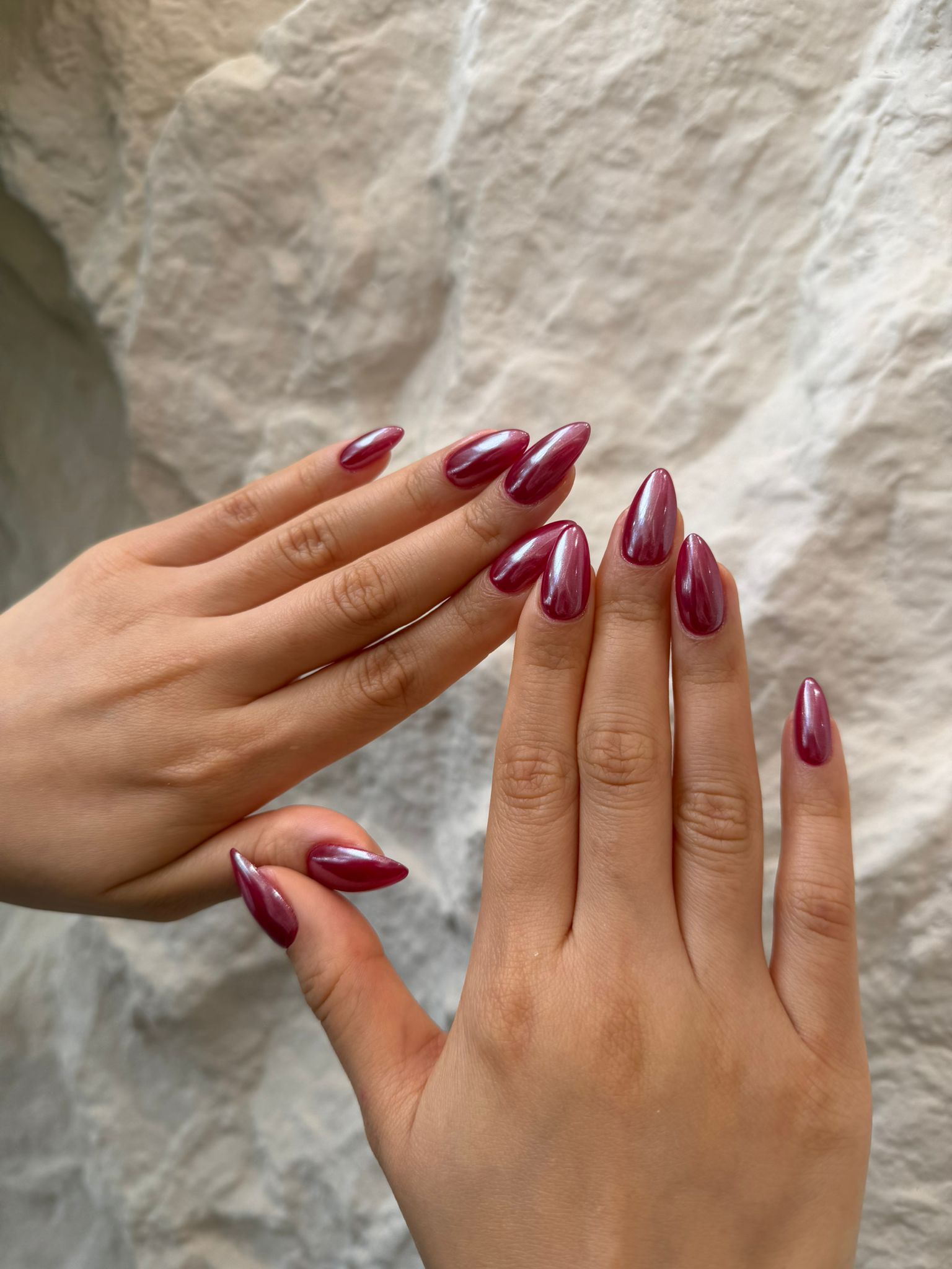 Deep cherry red chrome almond nails with a high gloss finish