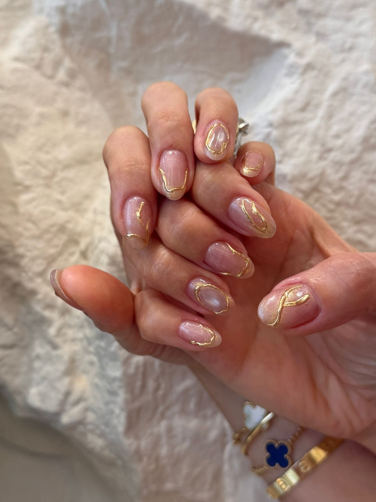 Sheer pearl nails decorated with sculpted liquid gold contour lines