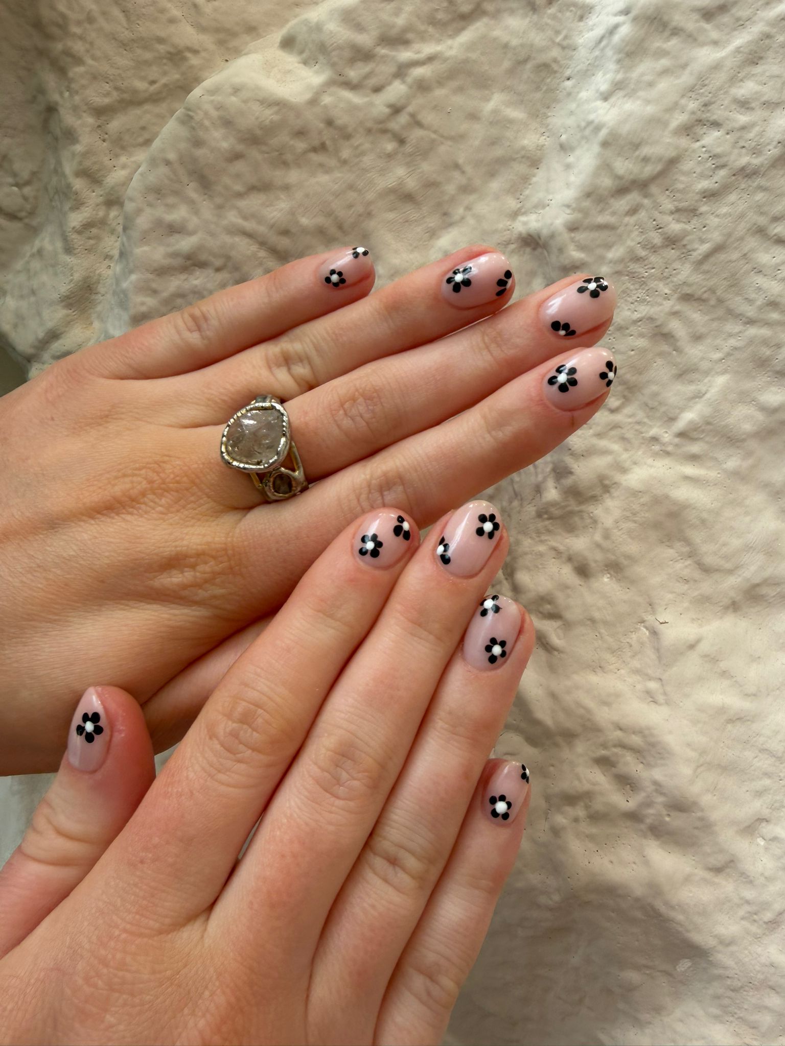 Short sheer nails with playful black and white daisy art