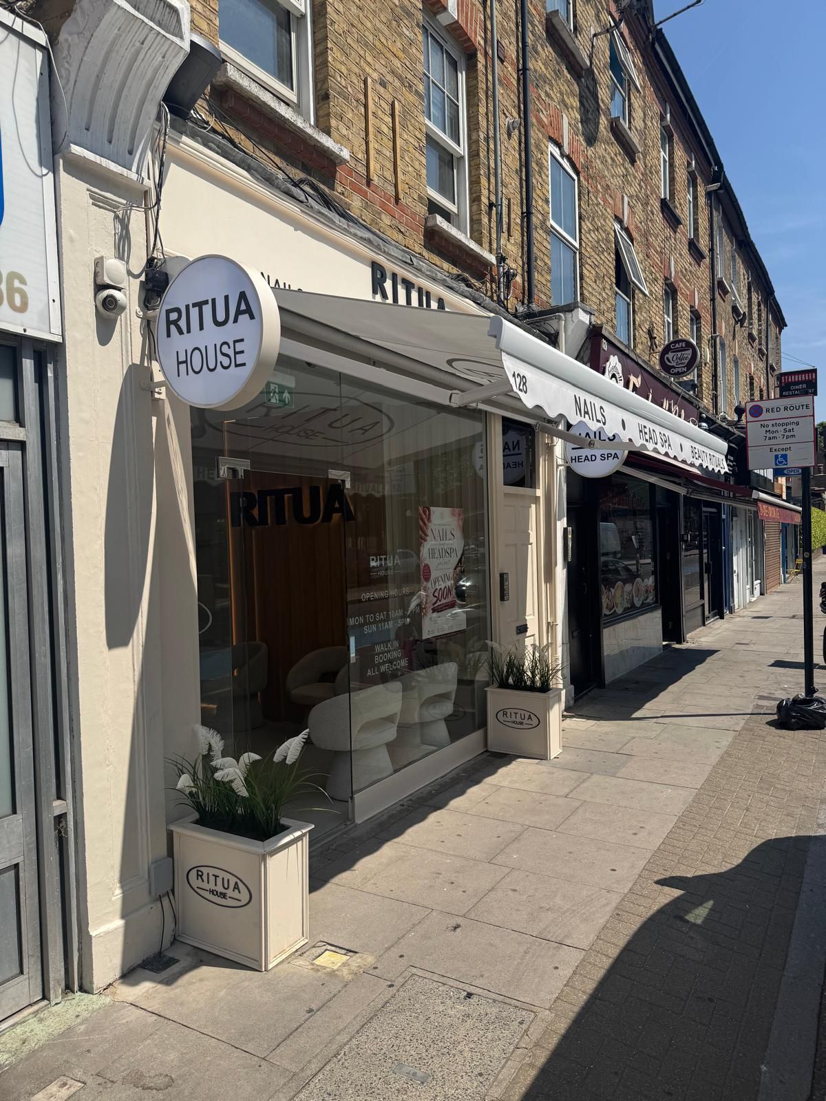 RITUA HOUSE exterior with cream awning and round salon sign