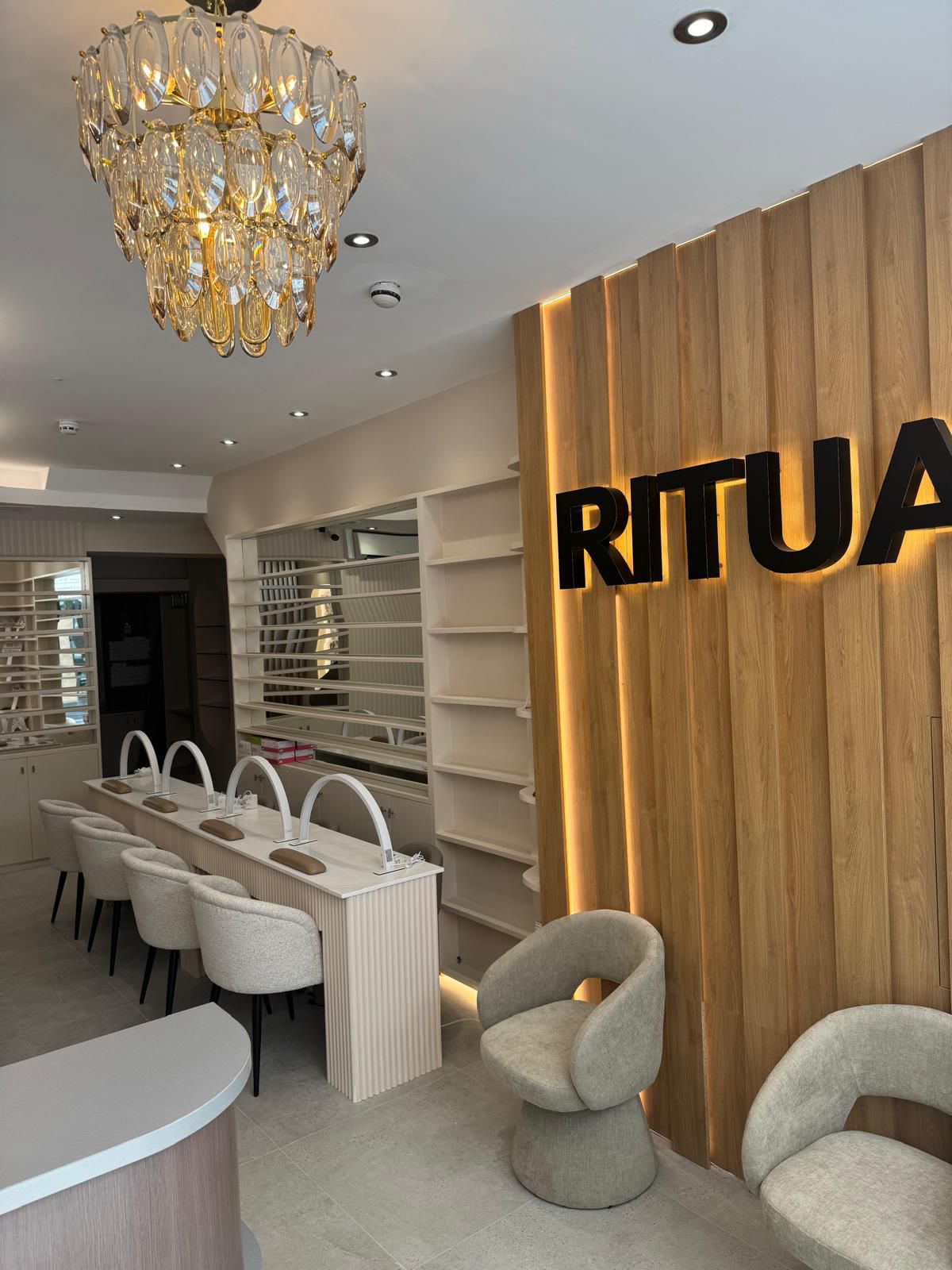 RITUA HOUSE interior with manicure bar, waiting chairs and illuminated wood feature wall
