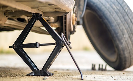 A car with it's tyres rotated and lifted on car jacks