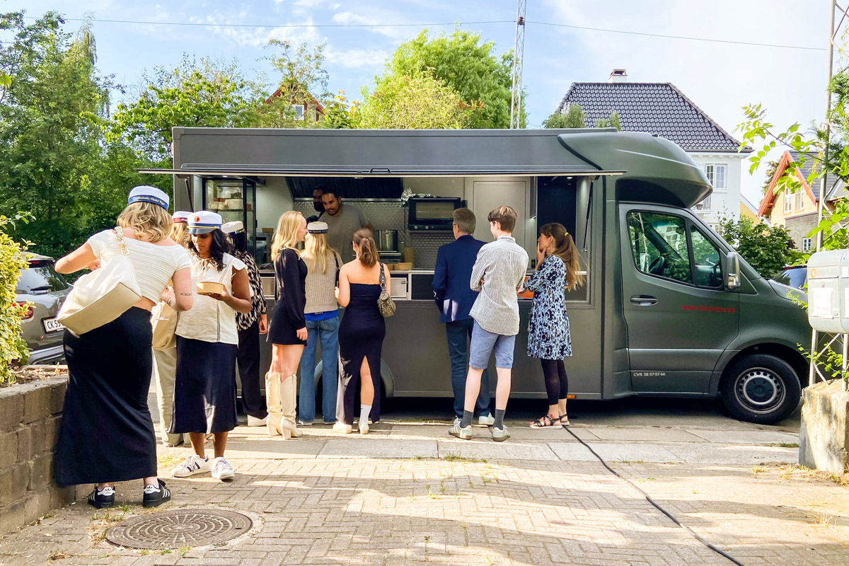 En foodtruck serverer burgere fra vejen til sulte gæster ved et studentergilde