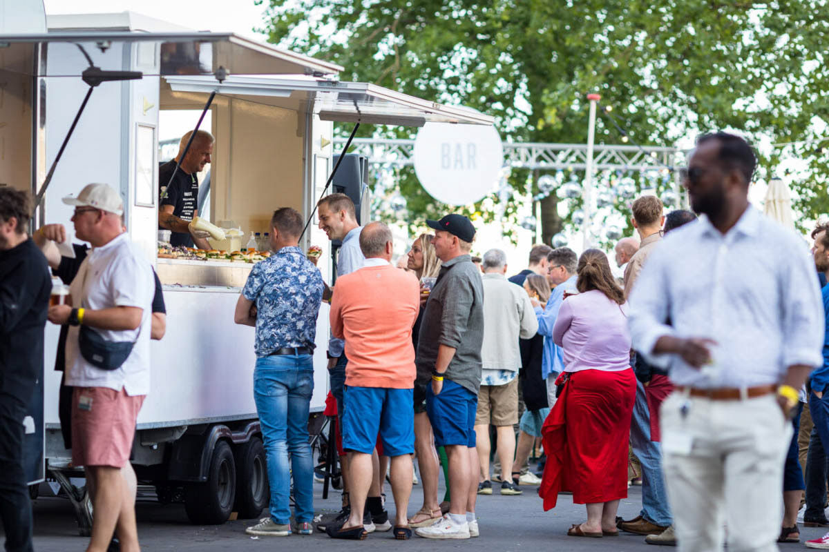 Food truck with queuing guests at an outdoor festival event