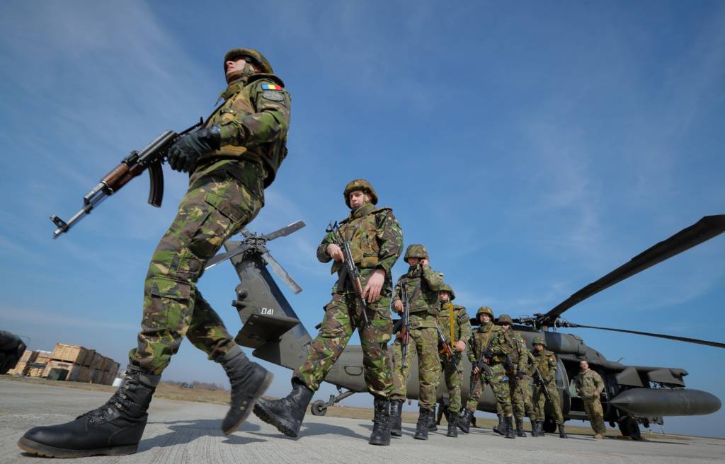Hadang laju Rusia, NATO kirim pasukan tambahan ke Laut Hitam.Tentara Rumania berjalan di sebelah Batalyon ke-2 Angkatan Darat AS, Resimen ke-10, helikopter Brigade UH-60 Black Hawk 10 dalam sebuah latihan penyerangan udara gabungan AS-Rumania di pangkalan udara Mihail Kogalniceanu, Rumania timur, Rabu, 8 Maret 2017. (Foto: Vadim Ghirda/AP)