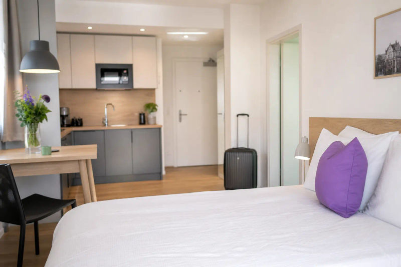 Hell möblierte Ferienwohnung mit Koffer an der Tür