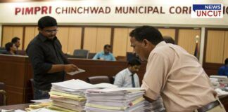 Officials reviewing tender documents at the Pimpri Chinchwad Municipal Corporation office. Stacks of files on the table highlight the volume of paperwork involved in the tender process. Concerns have been raised over alleged irregularities in the tendering system.