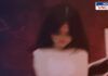 A blurred and distressed-looking girl in a white dress is in the foreground, with a dark and ominous background. A shadowy figure appears in the distance, creating a sense of fear and danger. The image has a somber and unsettling tone, symbolizing vulnerability and threat.