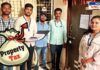 A group of municipal workers and officials standing at the doorstep of a property, collecting property tax. A large money bag icon labeled "Property Tax" is overlaid on the image, emphasizing the tax collection drive.