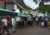 Swargate Bus Stand in Pune with a crowded scene of auto-rickshaws and passengers. Male rickshaw drivers are seen engaging with commuters, while buses and an elevated flyover are visible in the background. The busy transport hub reflects daily commuting activity in the city.