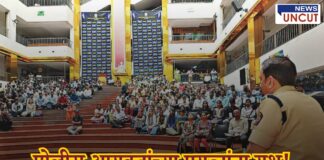 पोलीस अधिकाऱ्याच्या समोर बसलेली मोठी गर्दी, रहाटणी येथील रोजगार मेळाव्याचा एक दृश्य. पार्श्वभूमीत शाळेचा सभागृह आणि रंगमंच दिसतो आहे.