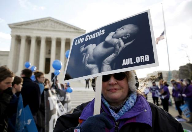 A protester holds up a sign in front of the U.S. Supreme Court in Washington
