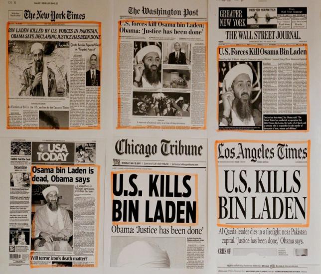 Newspaper headlines and clippings are posted on a wall inside a staff office at the White House in Washington