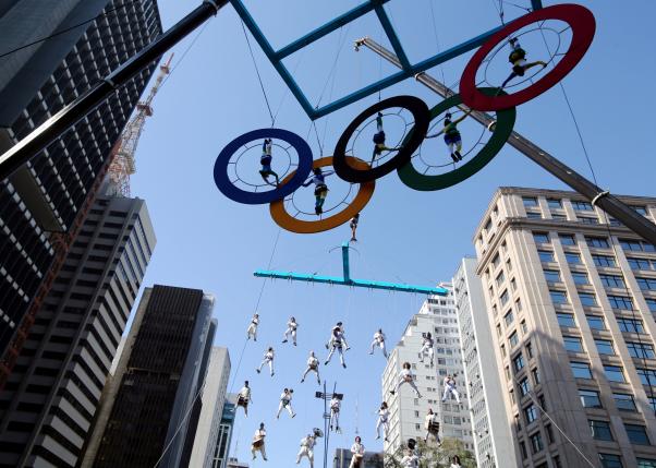 Acrobats perform on the Olympics rings at Paulista Avenue in Sao Paulo's financial center