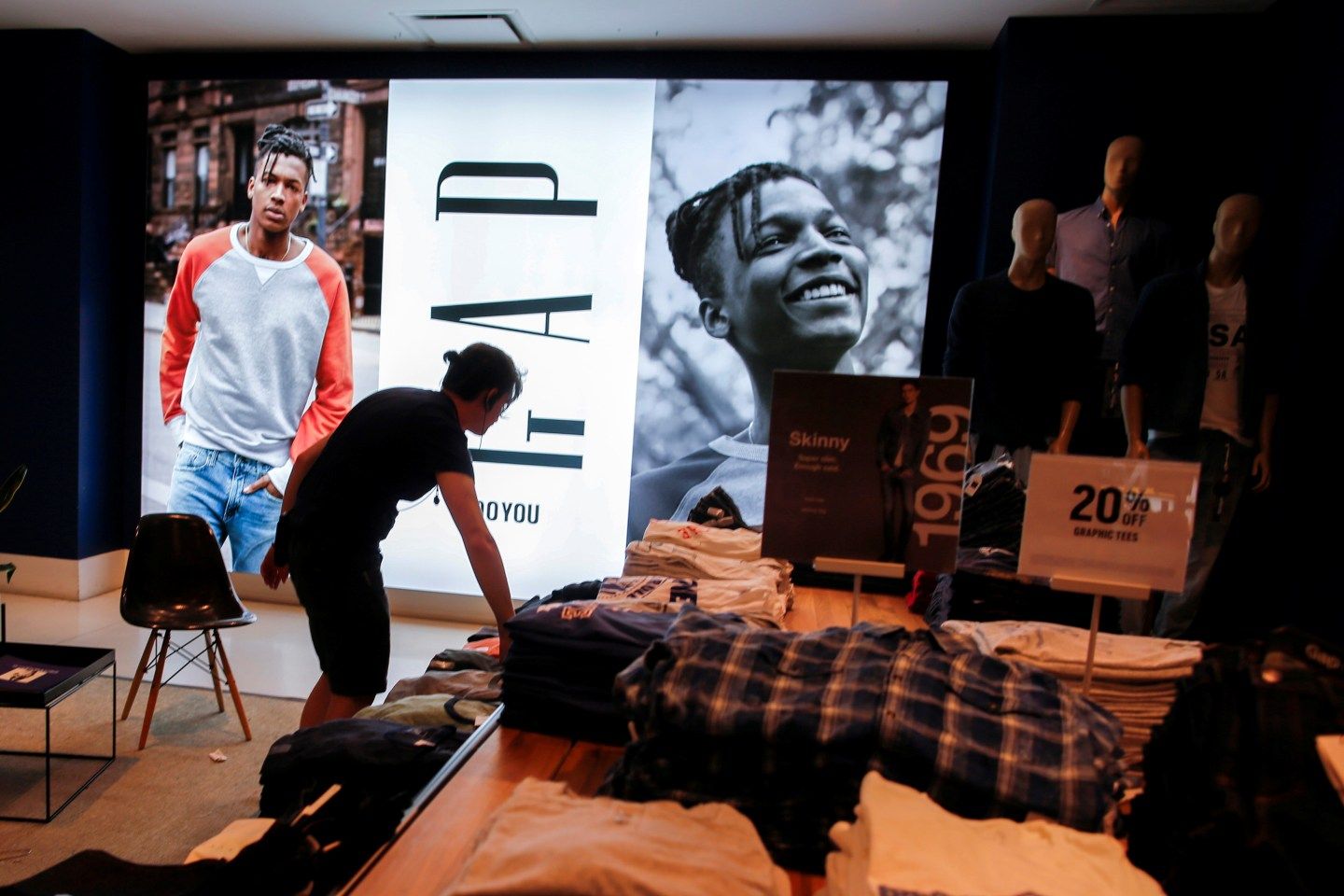A worker arranges clothes at the GAP clothing retail store in Manhattan, New York