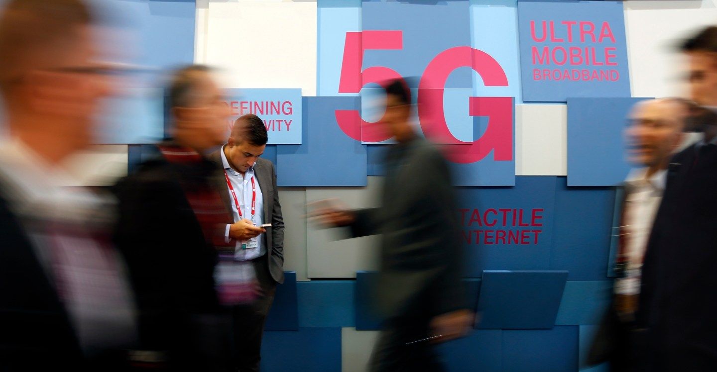 People walk past a 5G banner during the Mobile World Congress in Barcelona