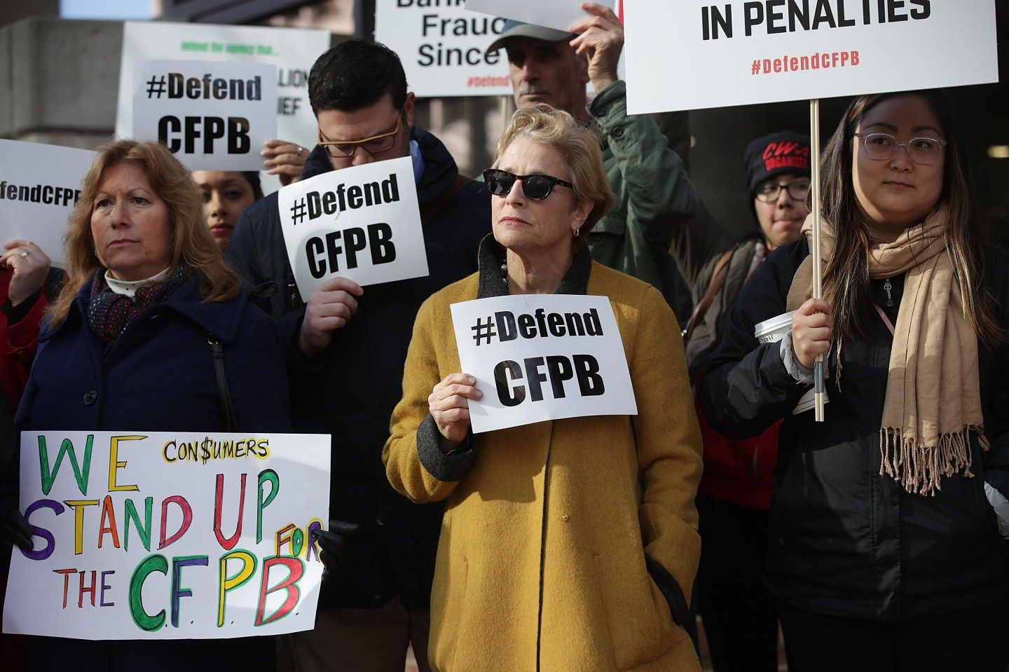 Supporters of the Consumer Financial Protection Bureau (CFPB) hold signs as they gather in front of the agency November 27, 2017 in Washington, DC.