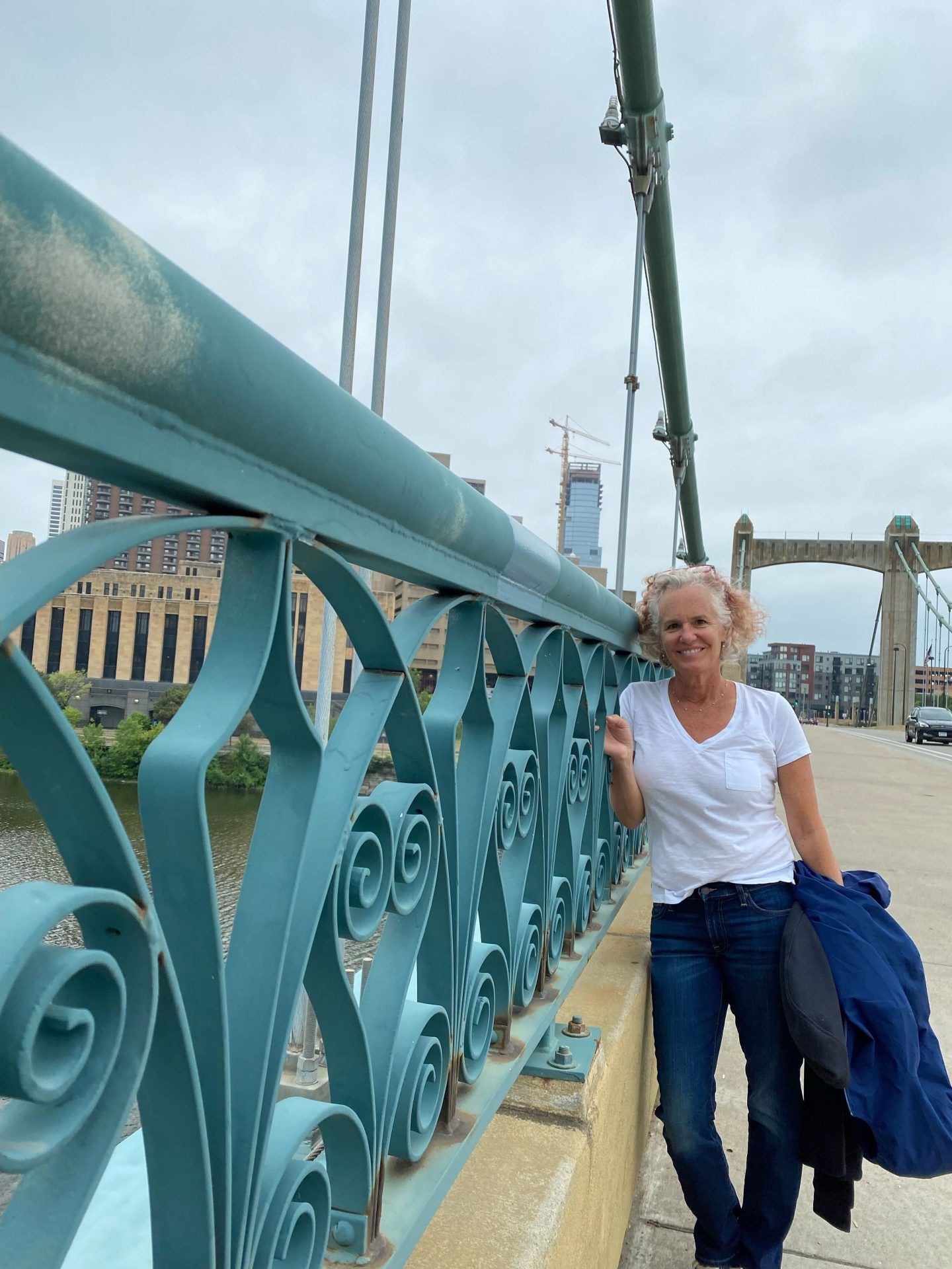 Nancy Wadsworth stands smiling on bridge