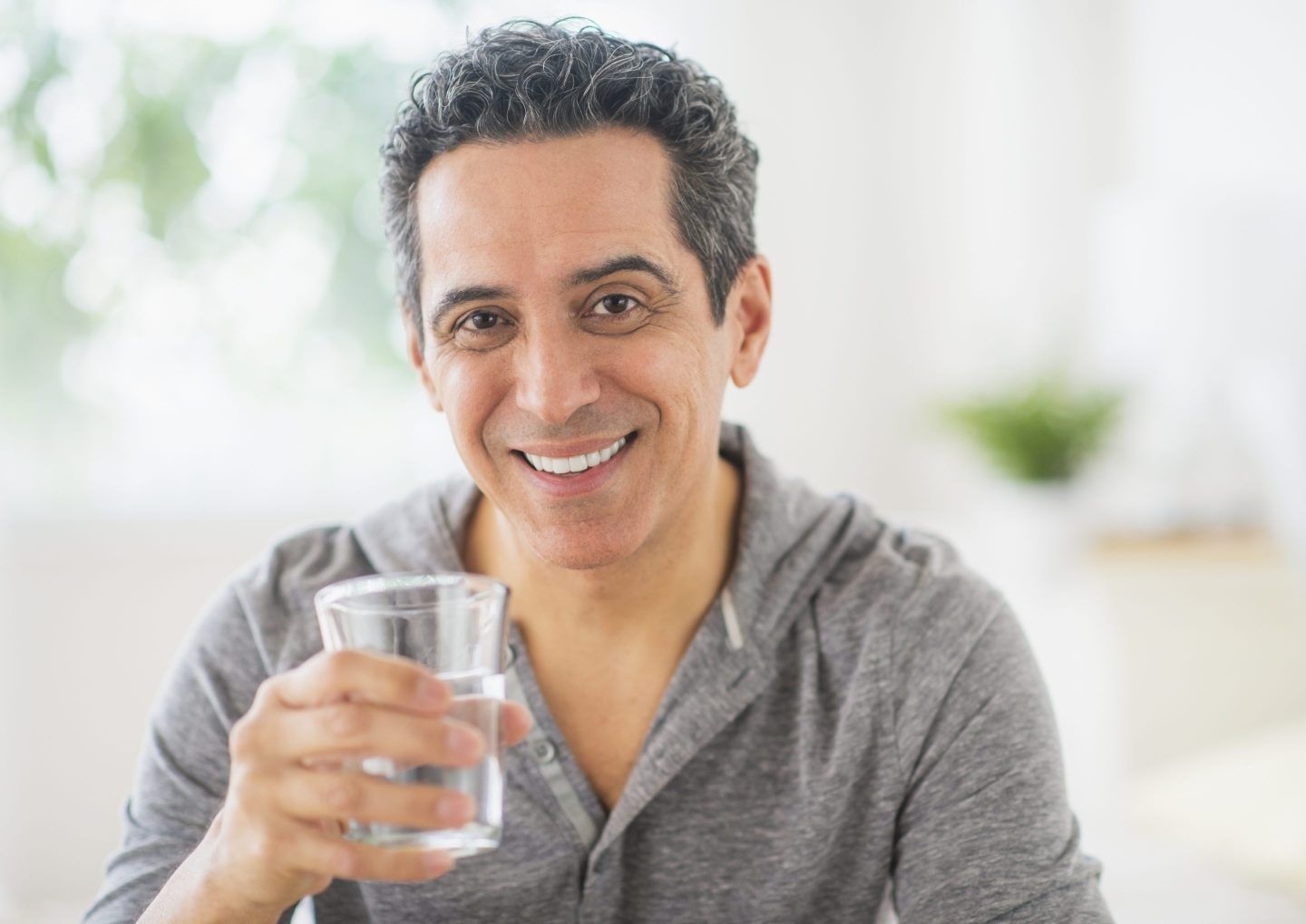 Photo of a man about to drink a glass of water