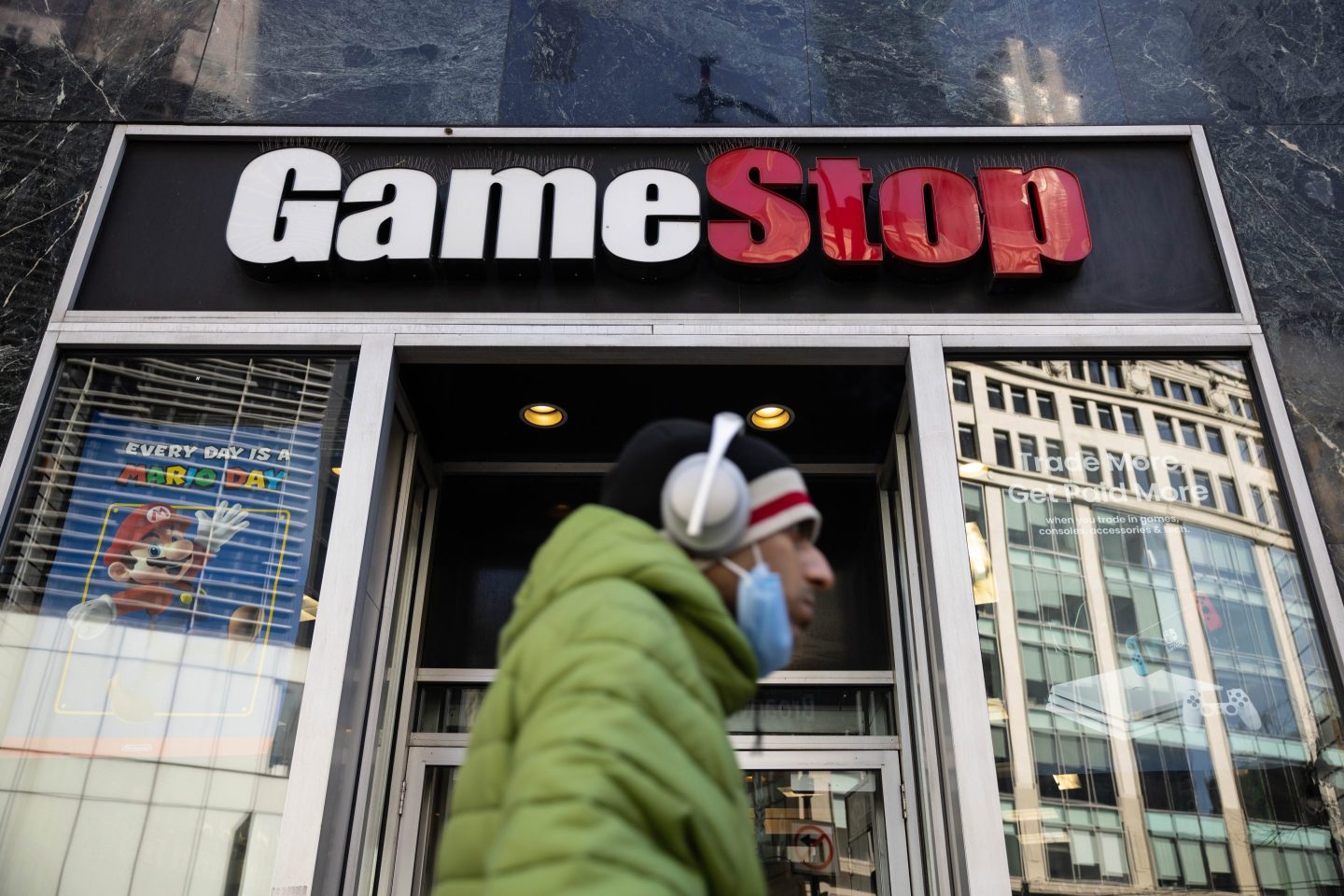 A man walks by a GameStop storefront.