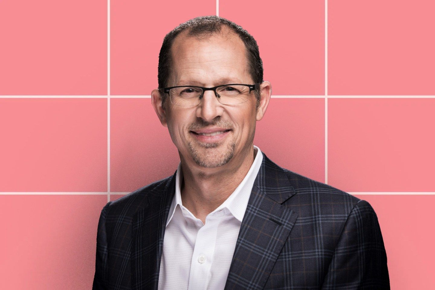 Coursera CEO Jeff Maggioncalda headshot is displayed in front of a pink-tiled background.