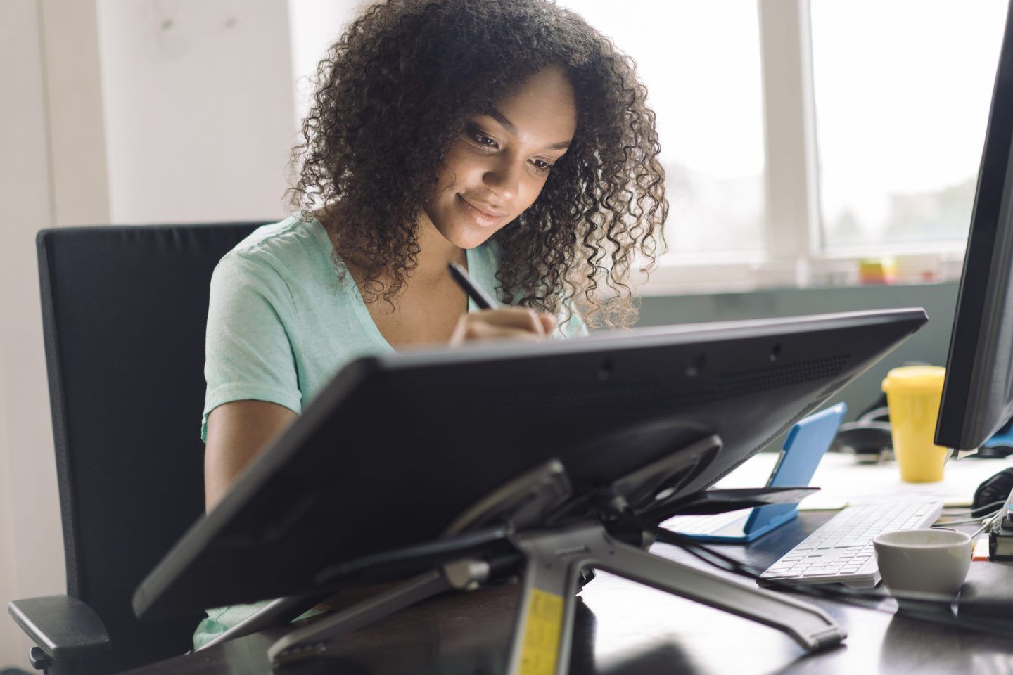 Young female designer drawing on digital tablet