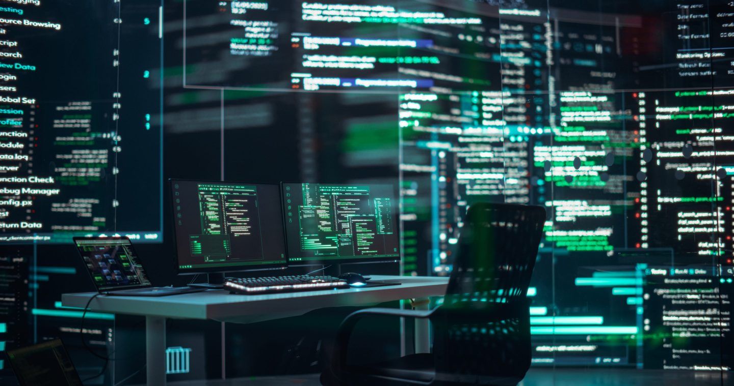 Computers with code surround an empty