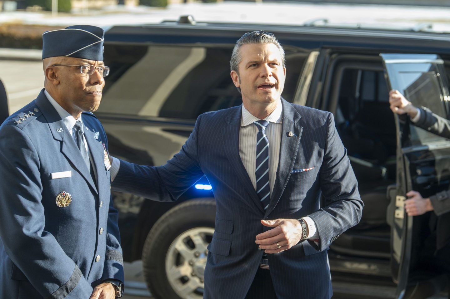 Defense Secretary Pete Hegseth, right, pats Chairman of the Joint Chiefs of Staff Gen. Charles Q. Brown Jr., on his shoulder as he answers questions from reporters after arriving at the Pentagon, on Jan. 27, 2025 in Washington.