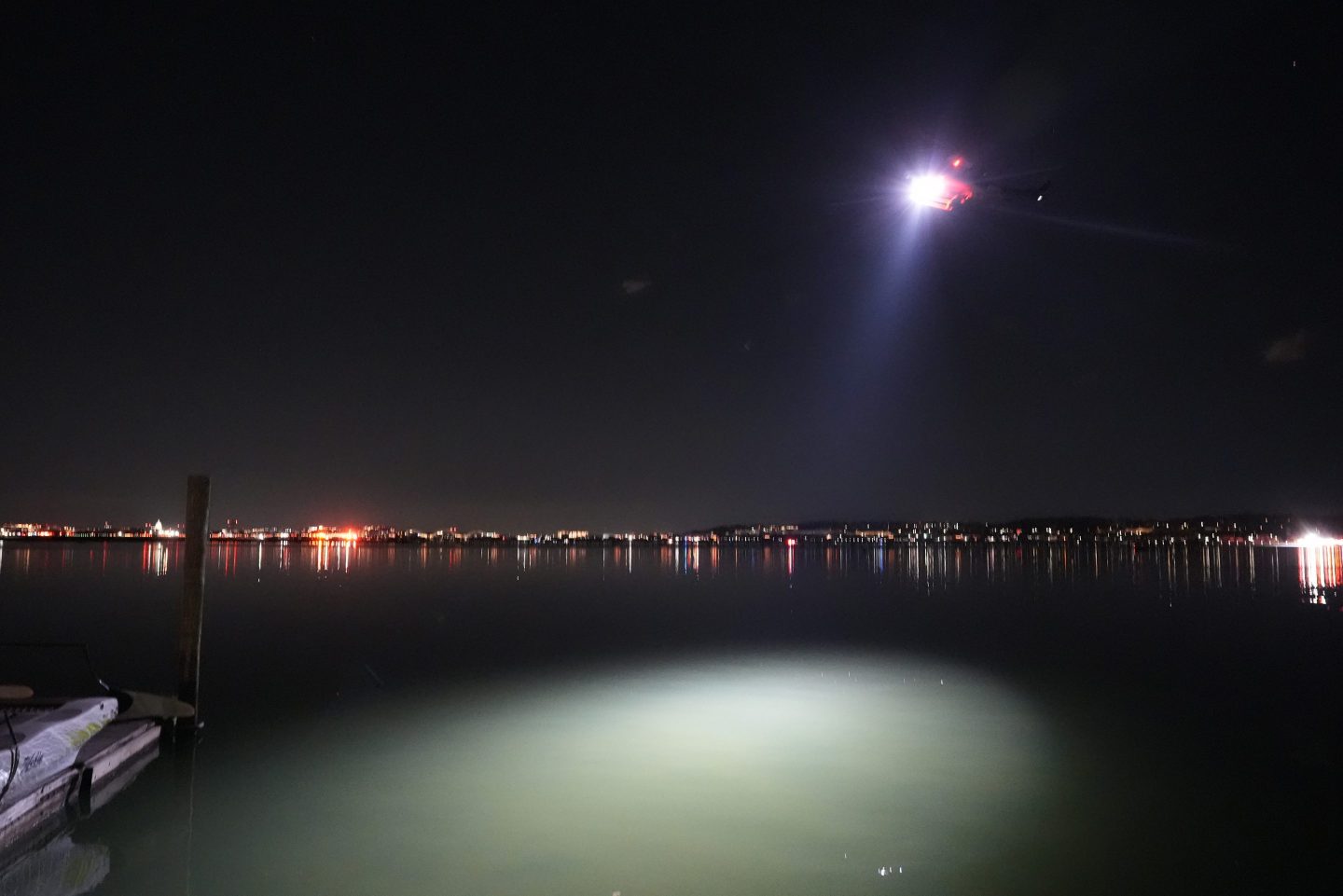 A helicopter uses a spotlight on the Potomac River near Ronald Reagan Washington National Airport, on Jan. 30, 2025, in Arlington, Va.