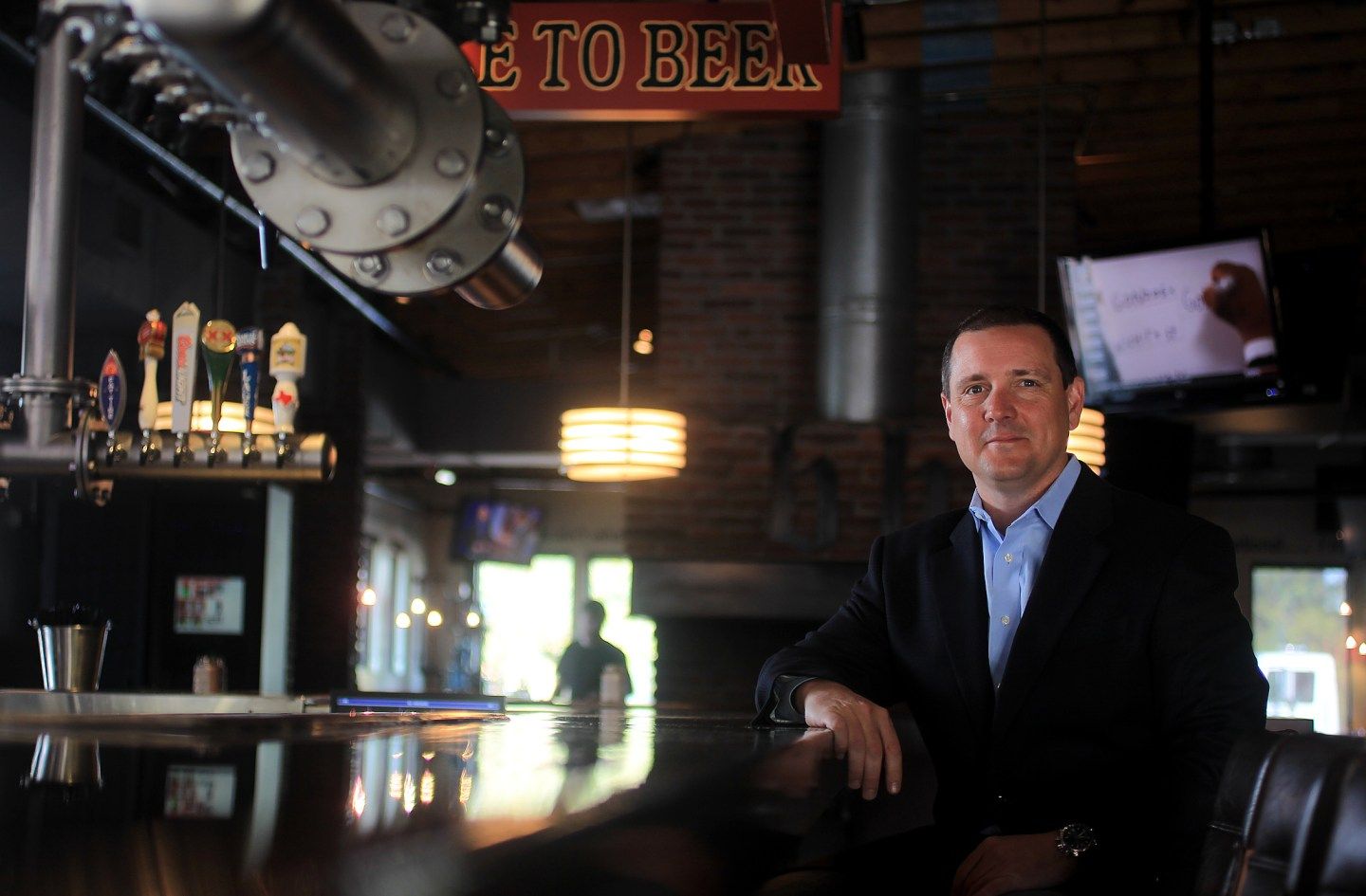 Ray Blanchette rests his arm on a bar and looks at the camera