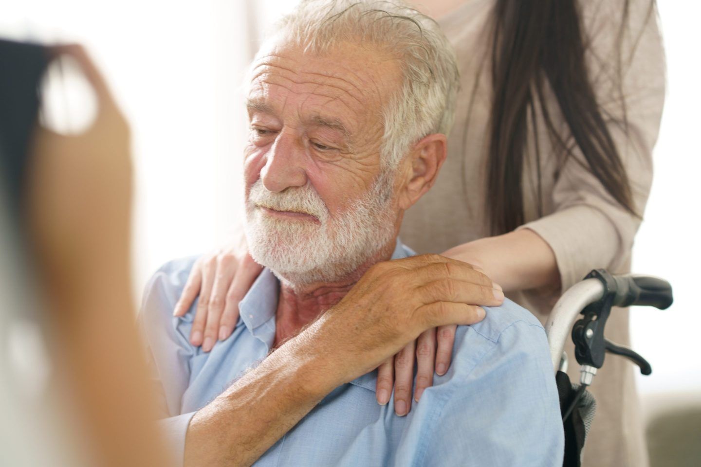 Closeup of older man with hand on his shoulder from someone behind him