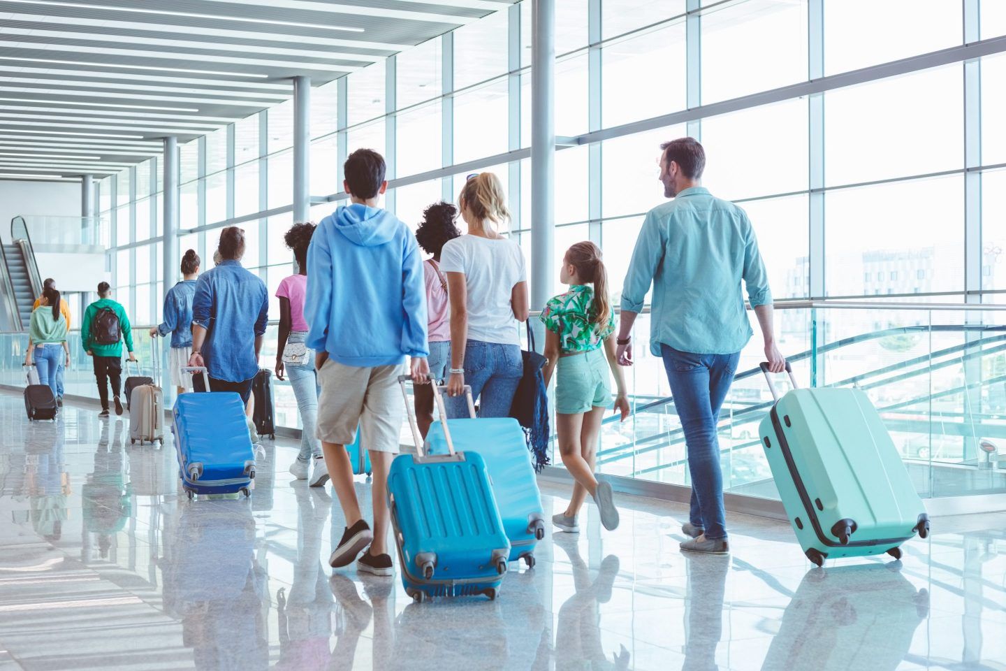 People dragging suitcases in an airport.