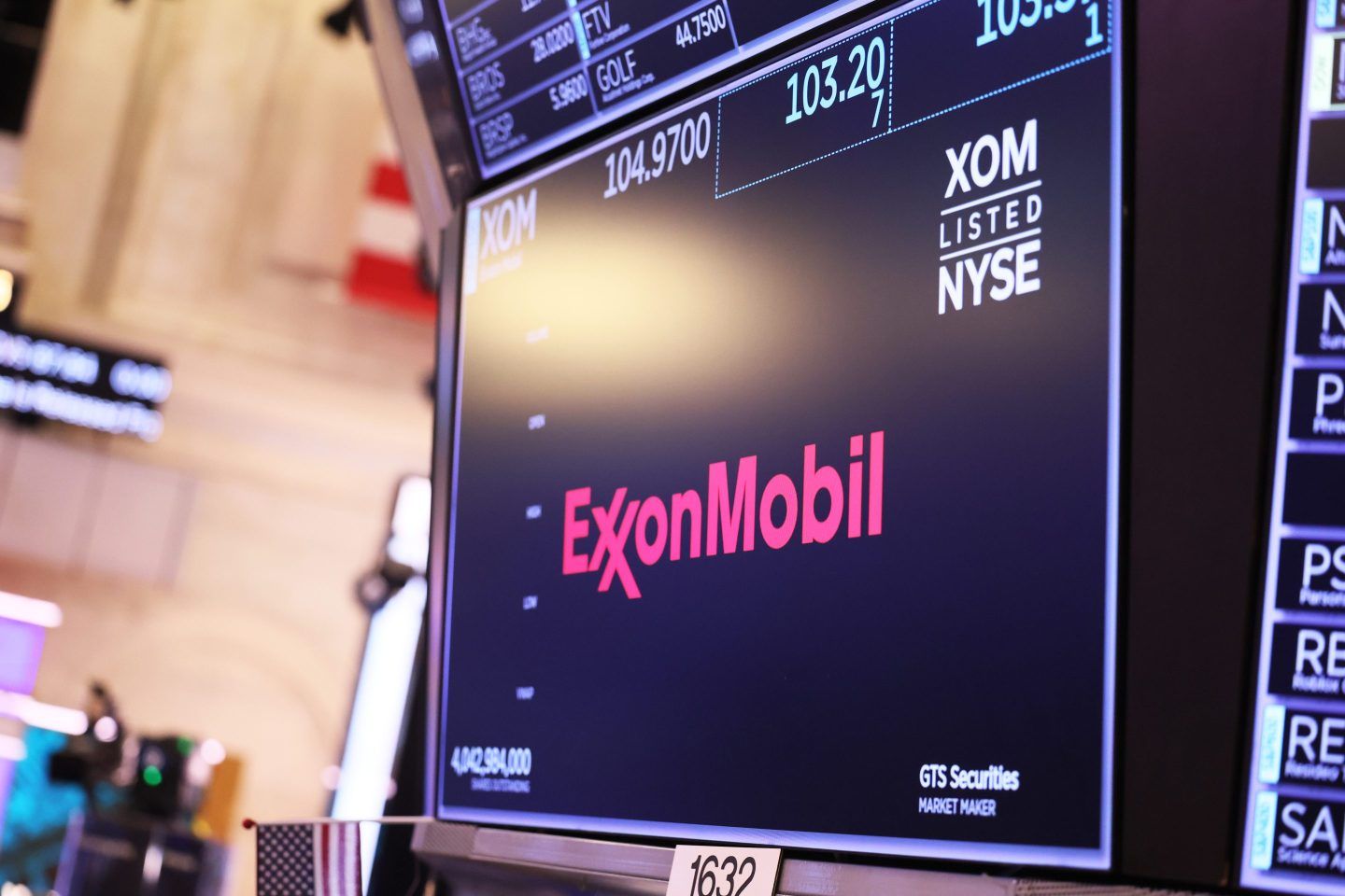 The ExxonMobil company logo is displayed as traders work on the floor of the New York Stock Exchange
