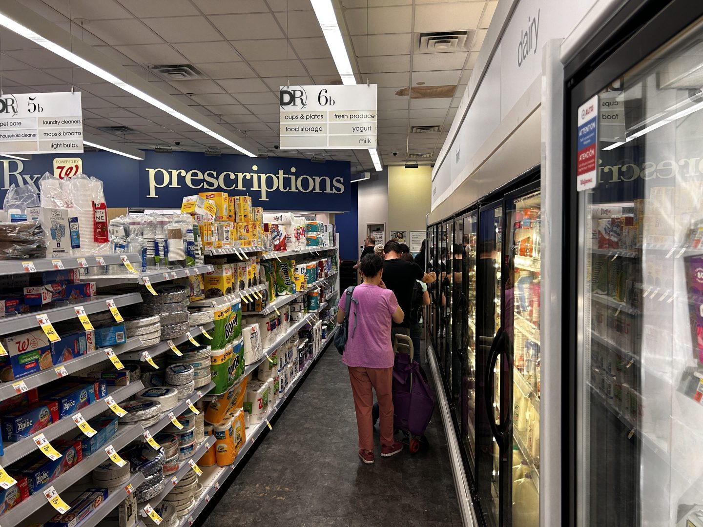 Woman waiting in line at Walgreens near refrigerators