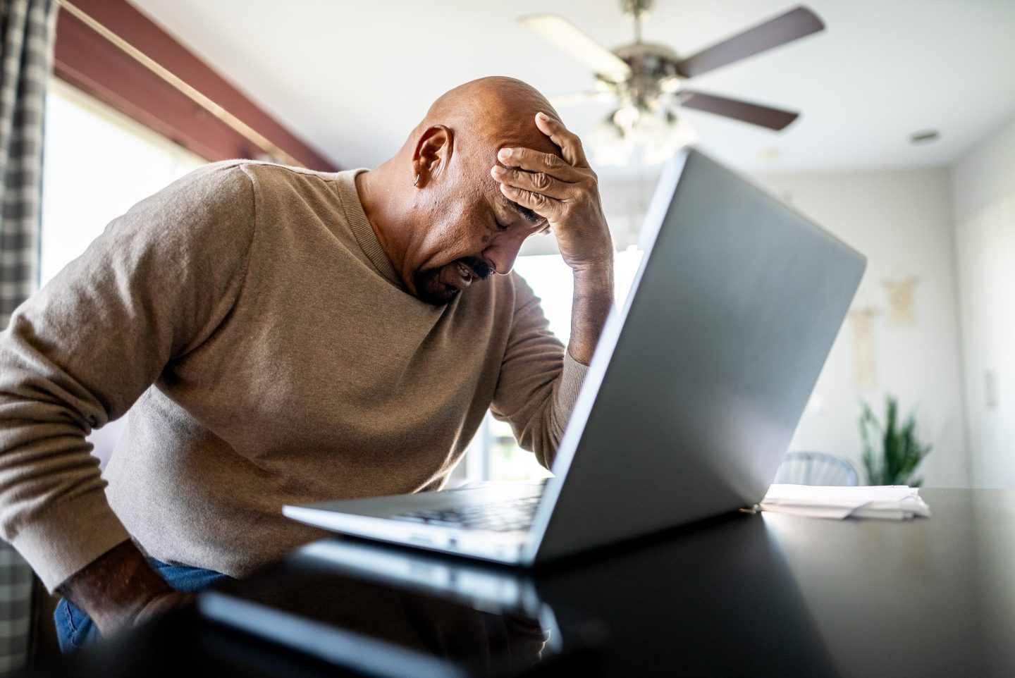 A person upset sitting in front of their laptop.
