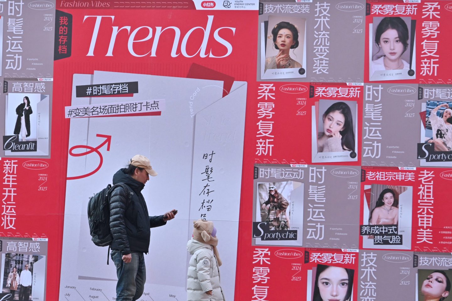 People walk past advertising for Chinese social networking and e-commerce app Xiaohongshu, also known as RedNote, at a shopping center in Beijing on Jan. 15, 2025.