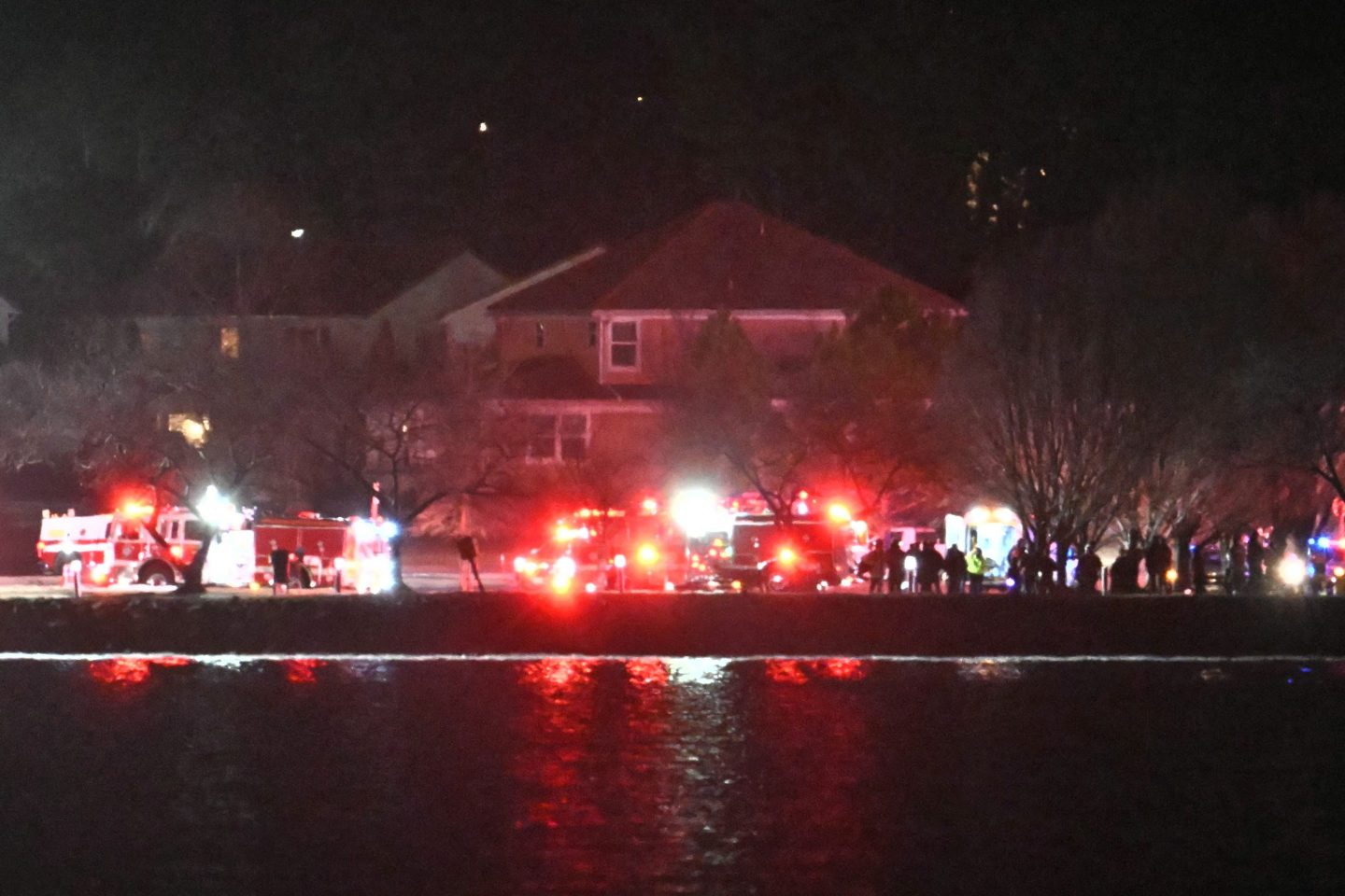 Lights from emergency vehicles are seen as rescue crews gather along the Potomac River near Reagan National Airport in Washington, DC, after an air crash on January 29, 2025. A passenger jet from Kansas crashed into Washington's Potomac River after colliding mid-air with a military helicopter near Reagan National Airport, officials said Wednesday, prompting a major emergency response and grounding all flights.