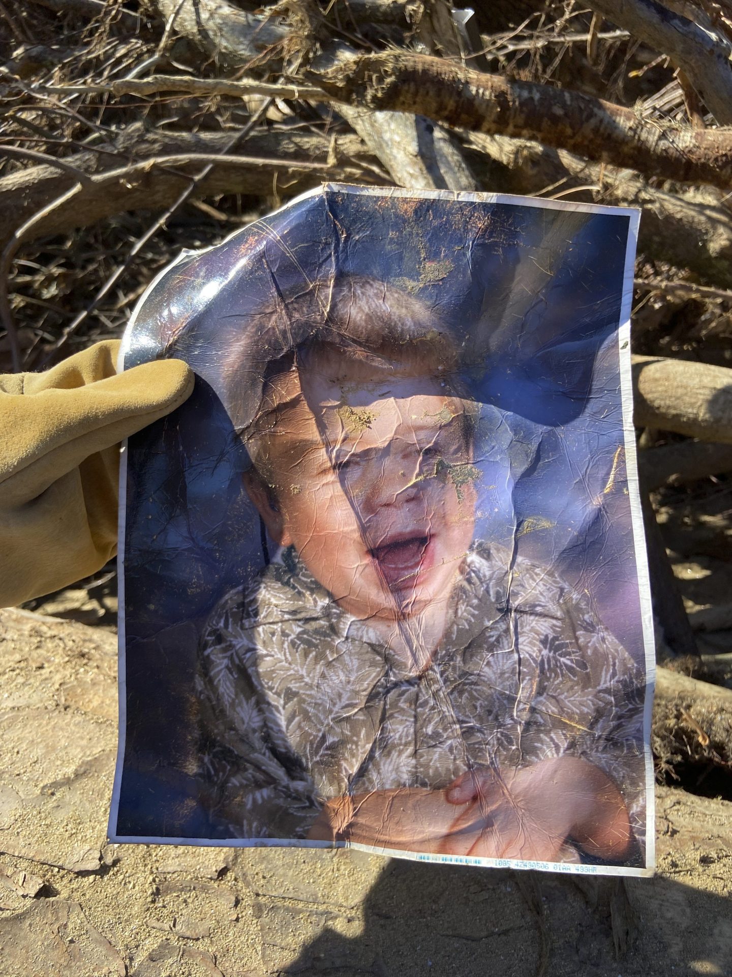 A crumpled photo rescued from Hurricane Helene, featuring a young boy smiling