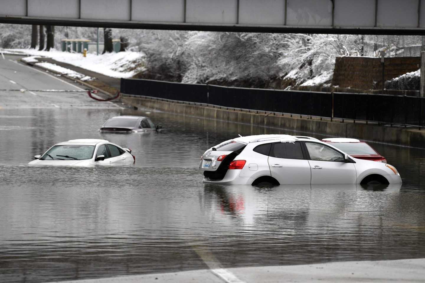 Cars sit in floodwaters at a railroad underpass in Louisville on Feb. 16, 2025.