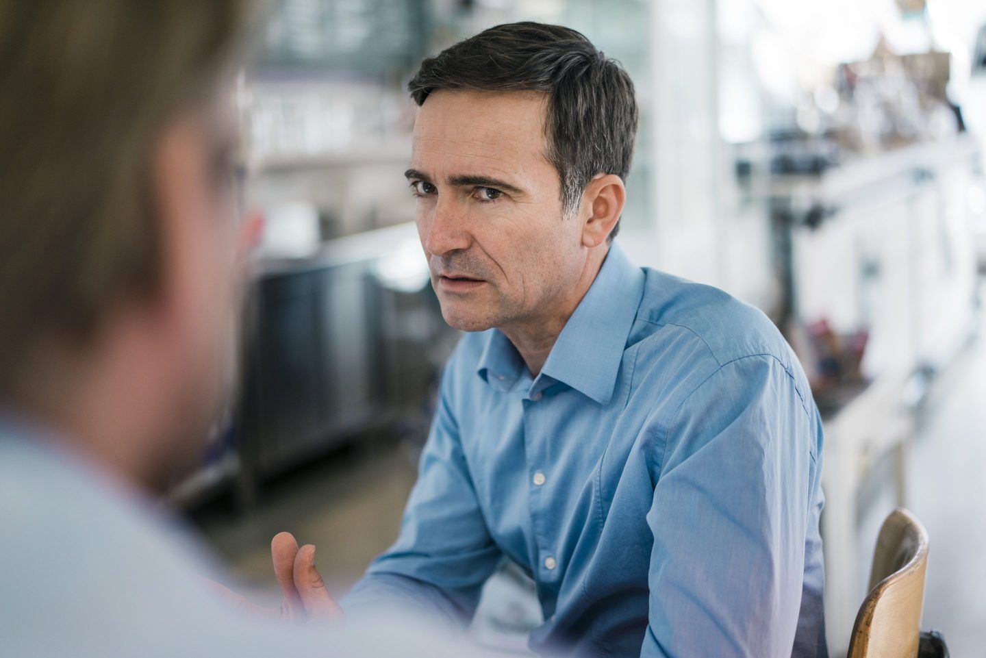 Worker is annoyed in conversation with co-worker.