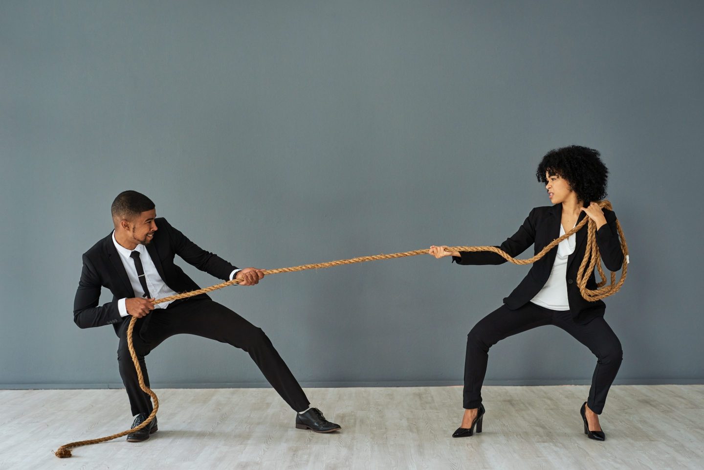 Two corporate workers playing tug of war. 