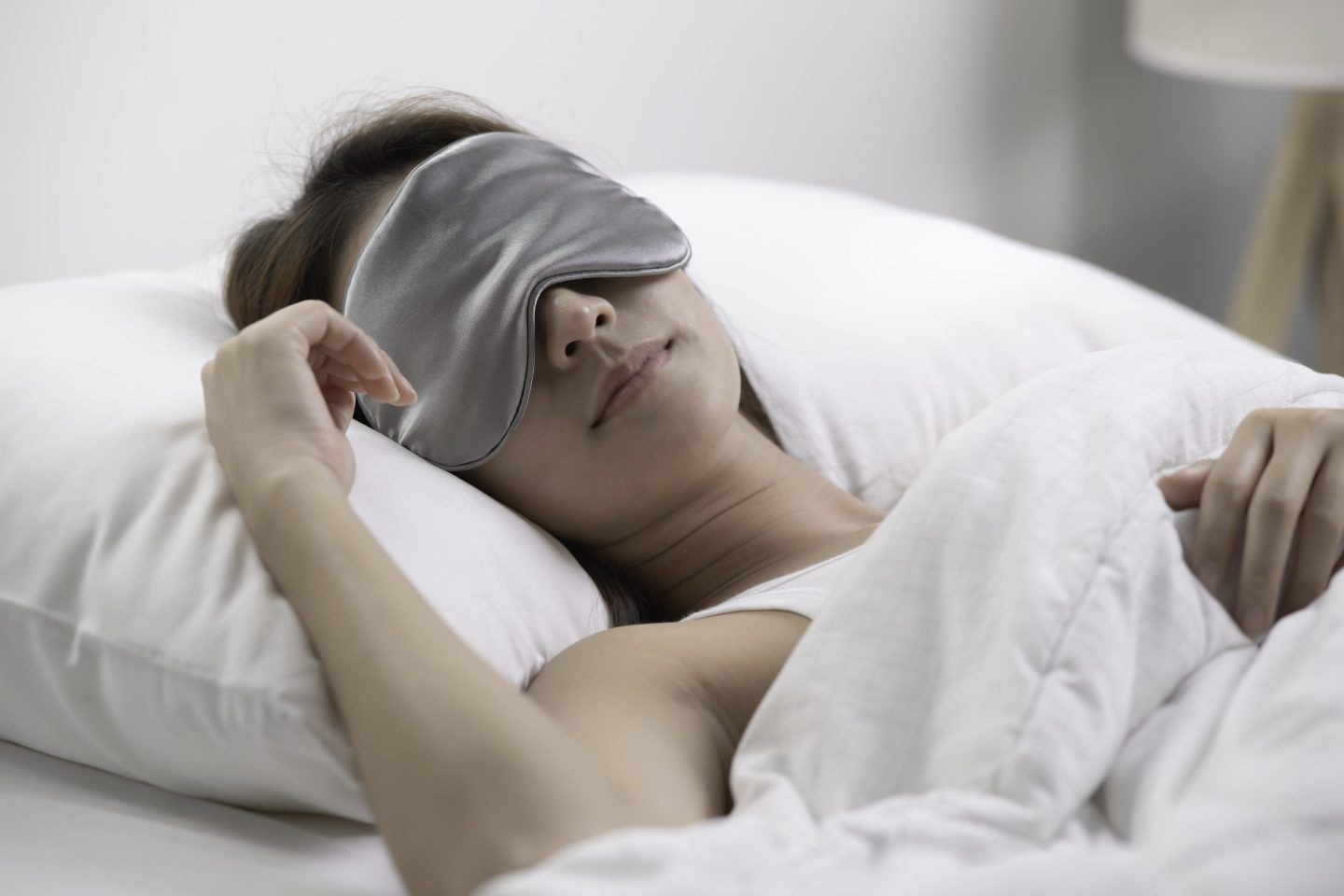woman in bed wearing a sleep mask
