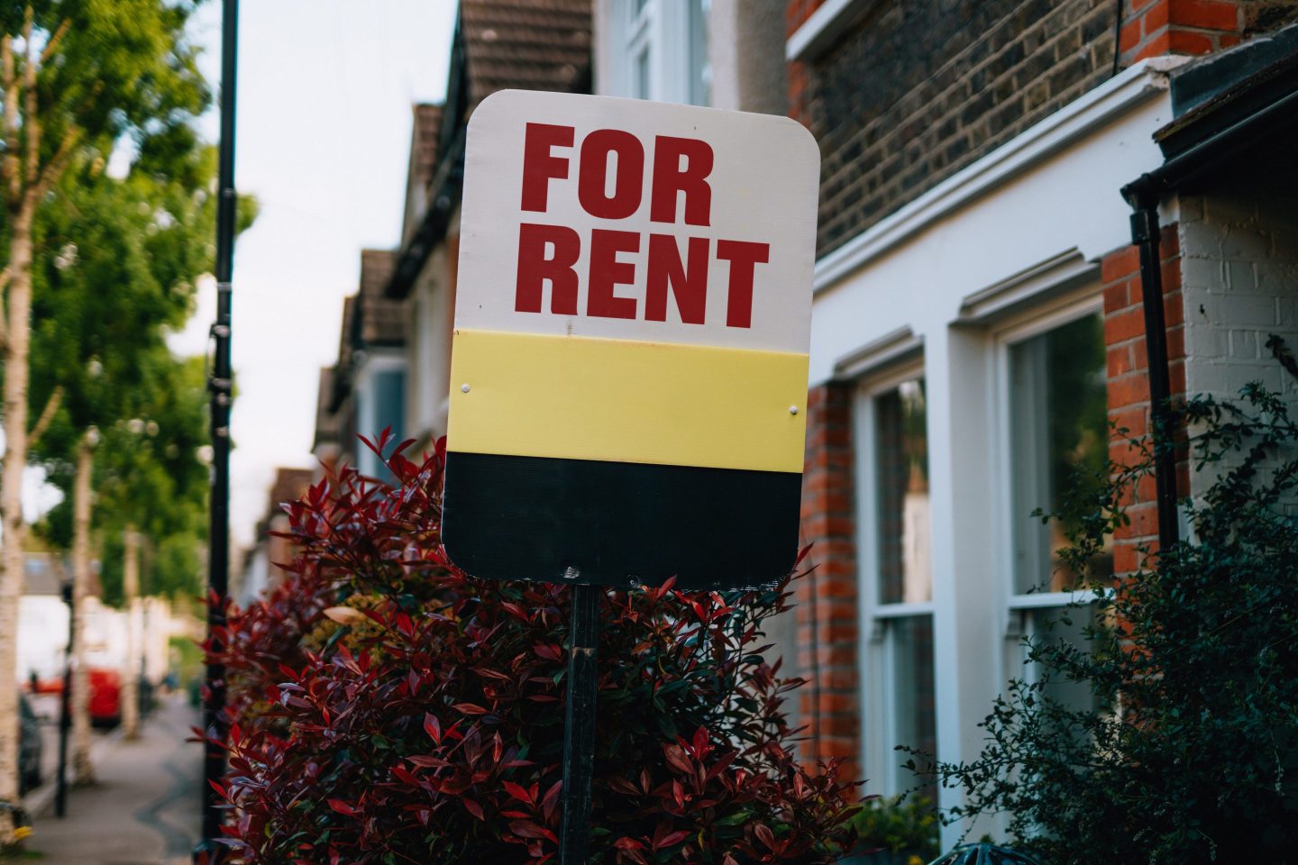 A For Rent sign hanging outside a home.