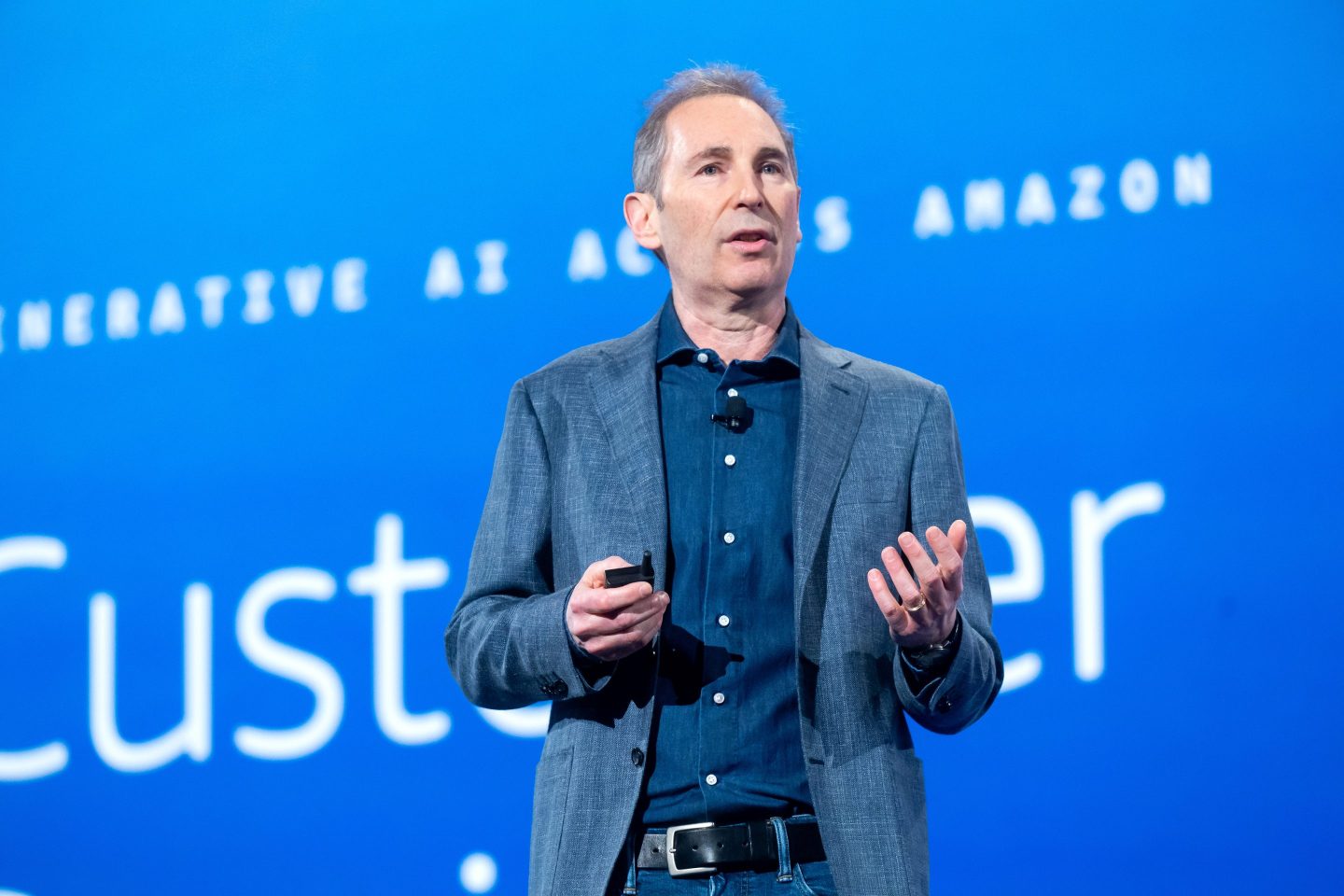 Andy Jassy speaking in front of a blue background