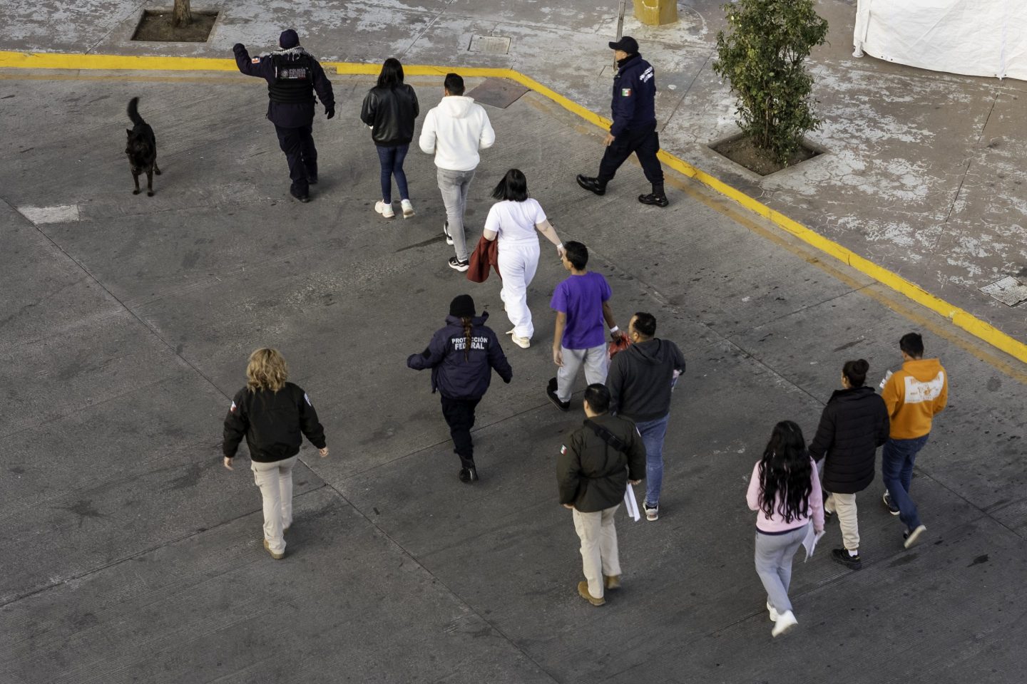 Mexican immigration officials and police escort deportees after they were sent back into Mexico on Jan. 22, 2025 as seen from Nogales, Arizona.